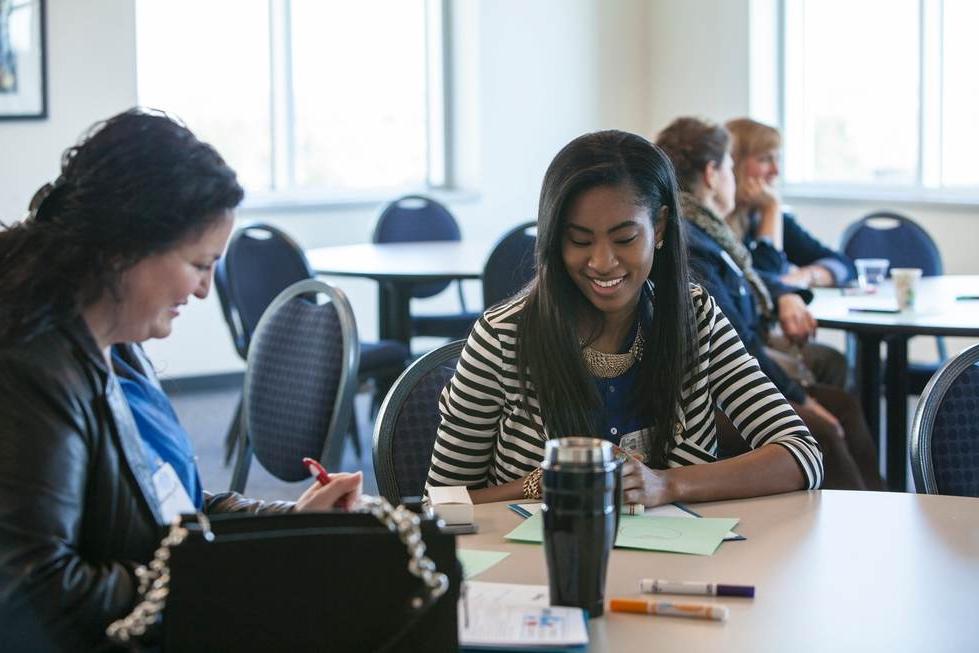 Student sitting at table with professor